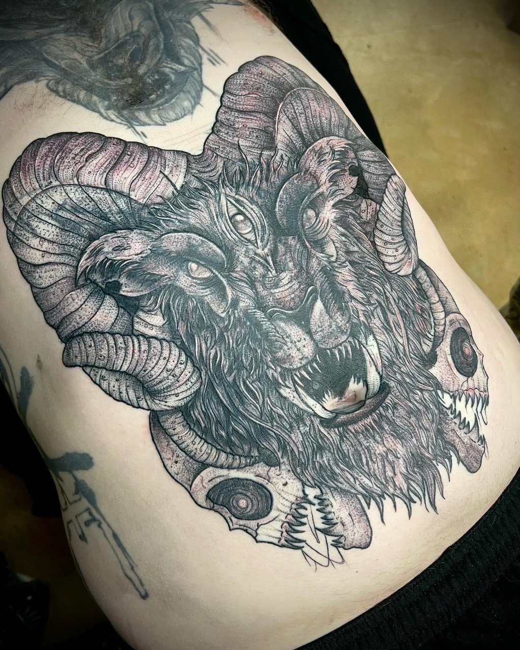 Three-eyed horned ram beast wreathed in skulls